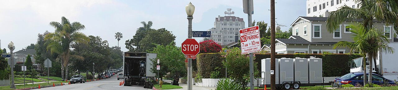 Production trucks, equipment and trailers line a residential street during setup for an on-location film shoot in Los Angeles.