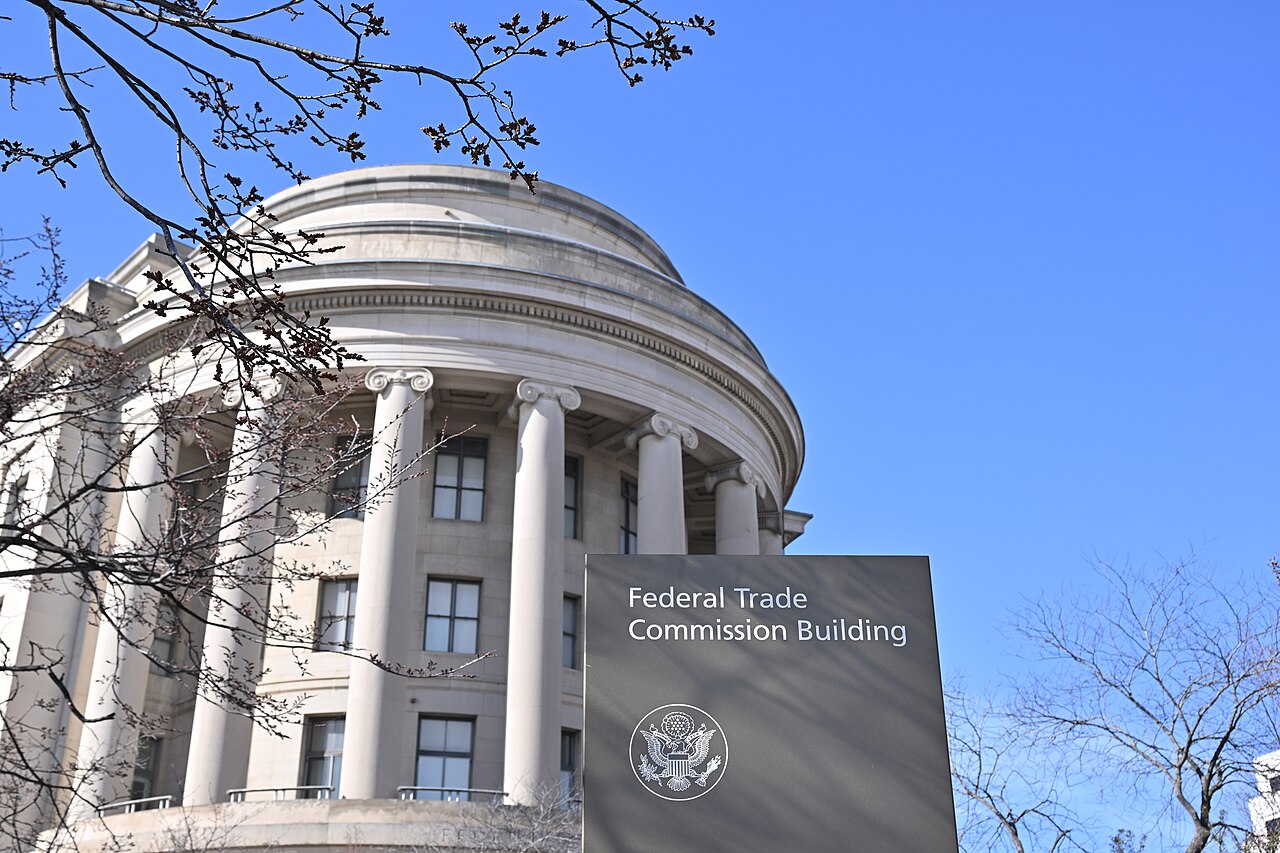 Curved stone facade and columns of the Federal Trade Commission building, with a sign identifying the agency.