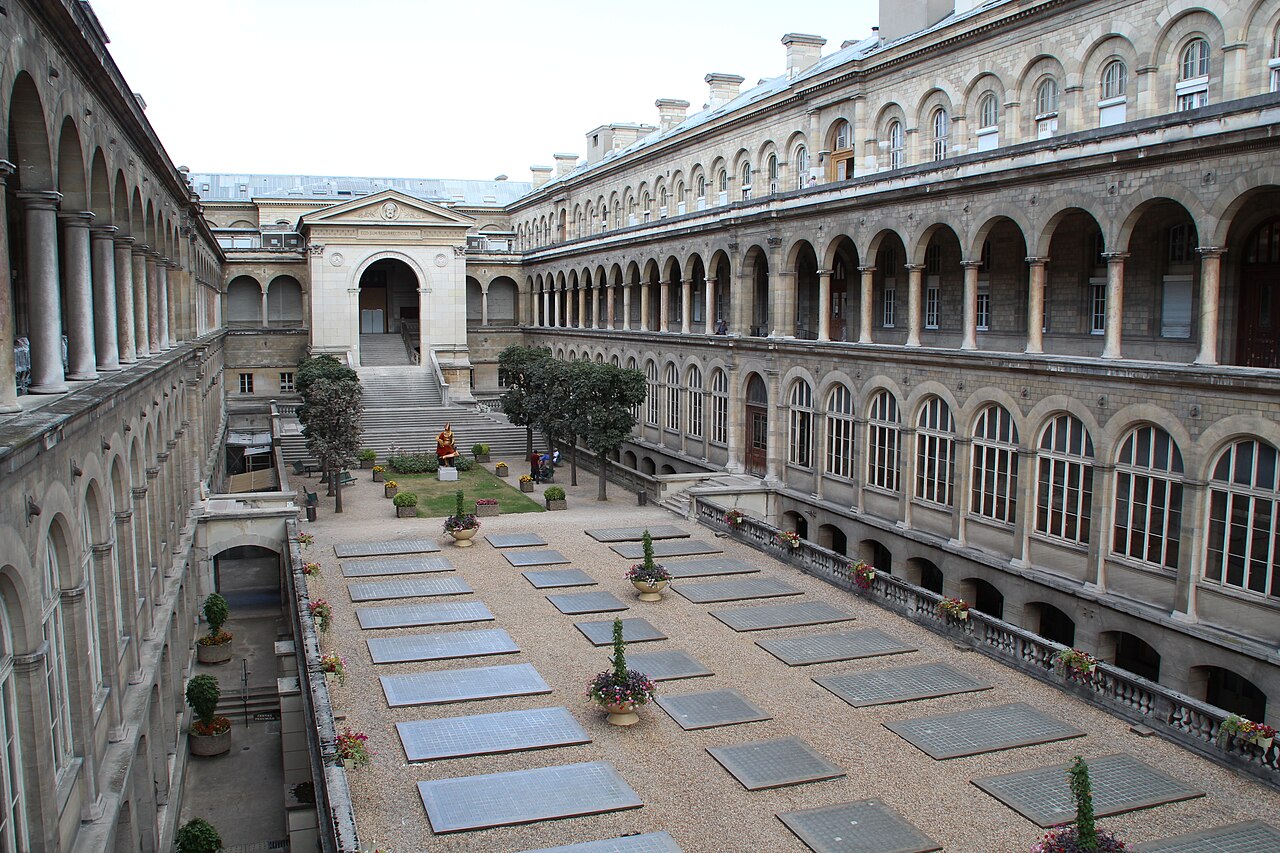 Stone arcades surround the central courtyard of the Hôtel-Dieu hospital in Paris, with skylights arranged across the courtyard floor.