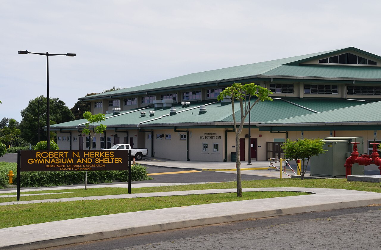Exterior of Robert N. Herkes Gymnasium and Shelter in Pāhala, Hawaiʻi, with its identification sign in front.