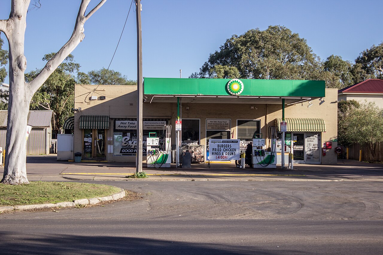 BP petrol station with fuel pumps and a shop beneath a green canopy.