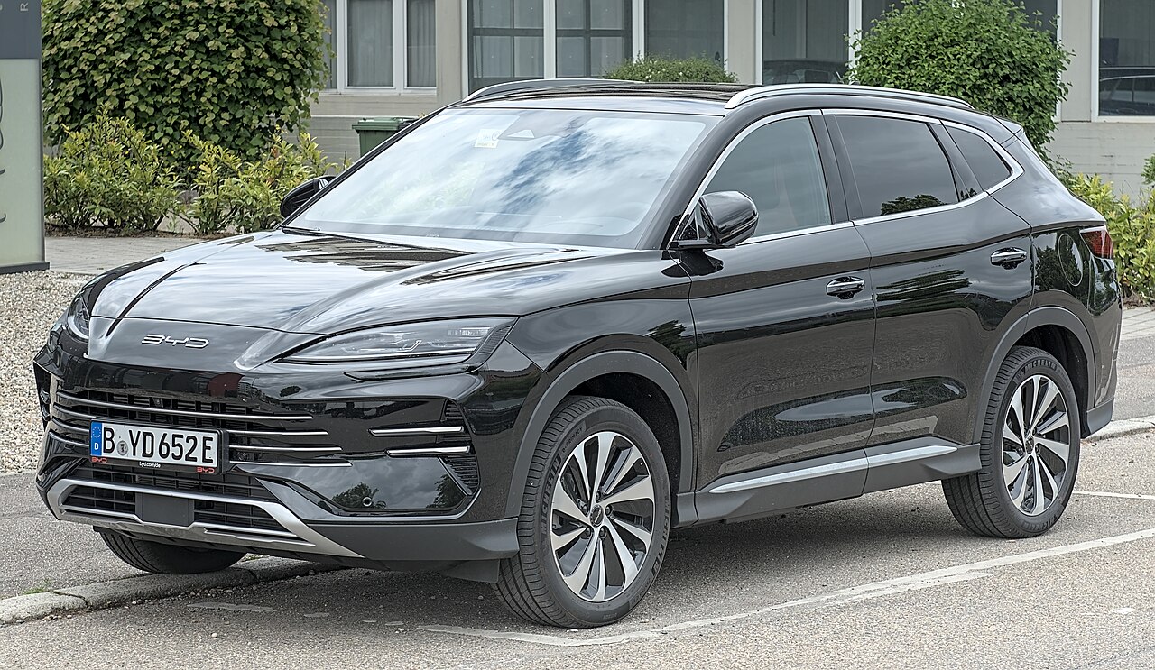 Black BYD Seal U DM-i plug-in hybrid SUV parked beside a curb, shown in a front three-quarter view.